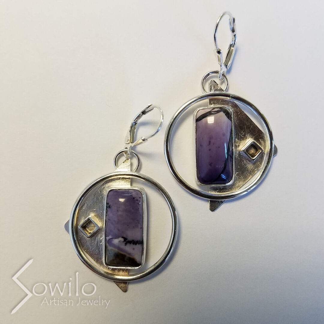 A pair of silver earrings with purple stones