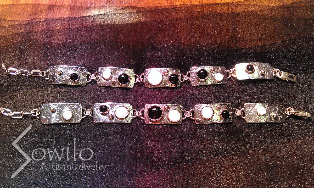 A pair of silver bracelets with black and white stones